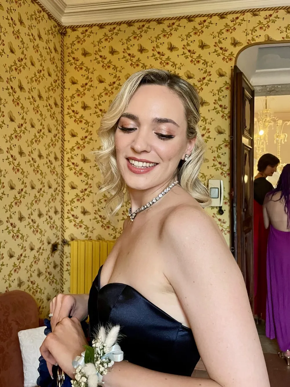 Invitata con abito blu e trucco dai toni caldi