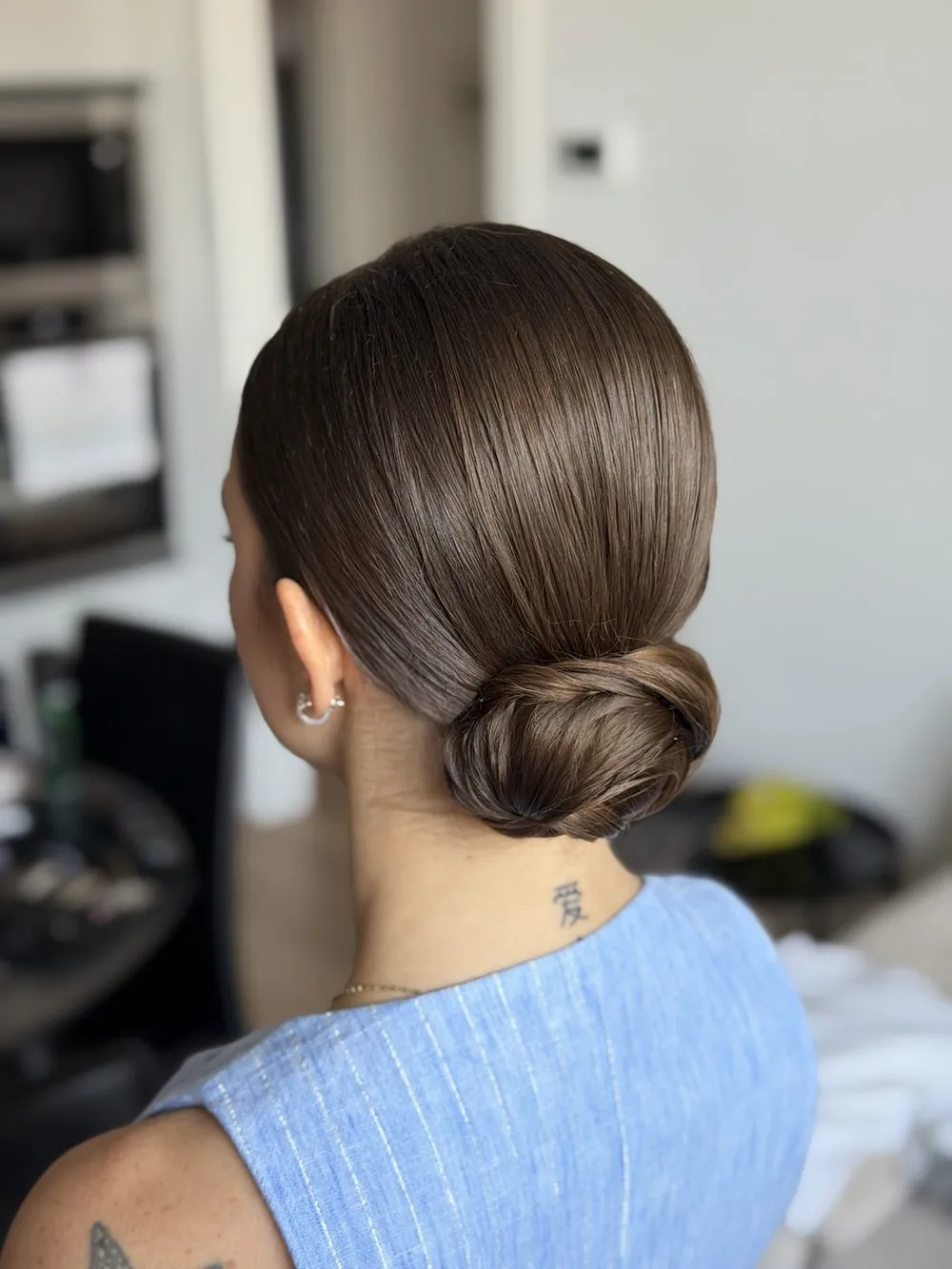 Chignon basso lucidissimo, raccolto ordinato visto da dietro
