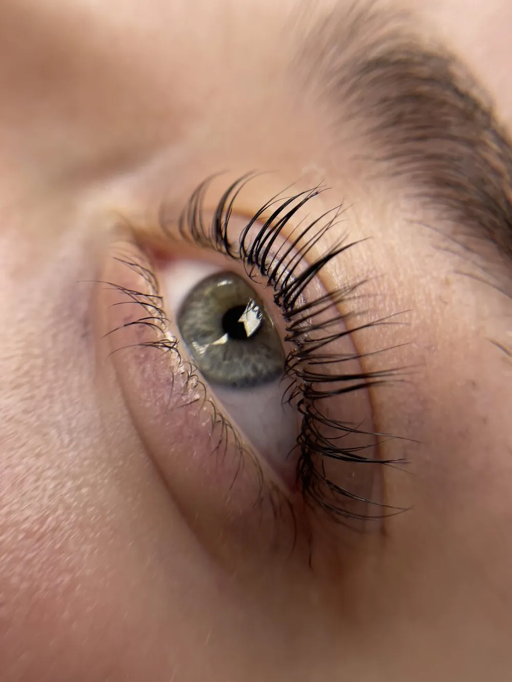 Ciglia laminate viste da vicino: il ventaglio aperto su un occhio chiaro