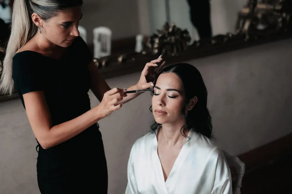 Sara Bonetti trucca gli occhi della sposa davanti allo specchio