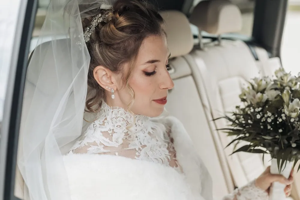 Sposa di profilo con velo e abito di pizzo