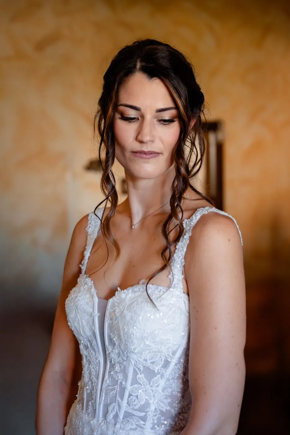 Sposa con onde scure e abito di pizzo
