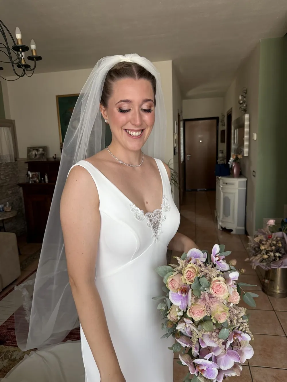 Sposa con velo lungo e bouquet di rose